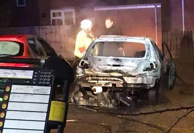 Firefighters battle the blaze which engulfed two cars