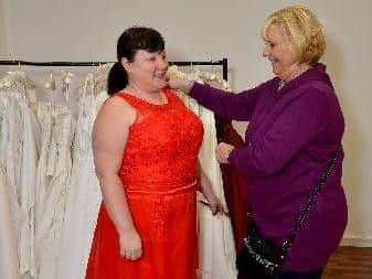 Kerrie West trying on a dress helped by Sandra Marshall