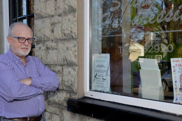 Richard Stringer with one of the broken windows.