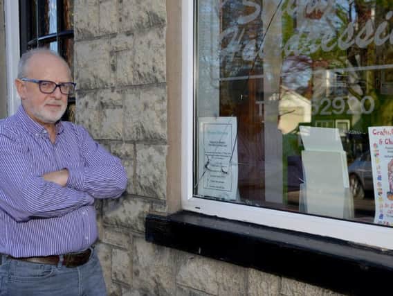 Richard Stringer with one of the broken windows.