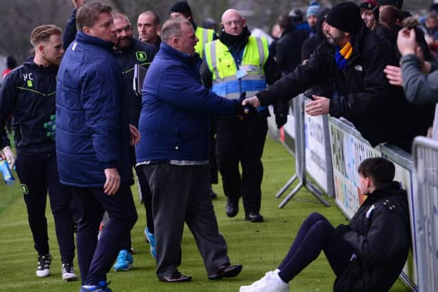 Steve Evans greets a fan before kick-off against Barnet.