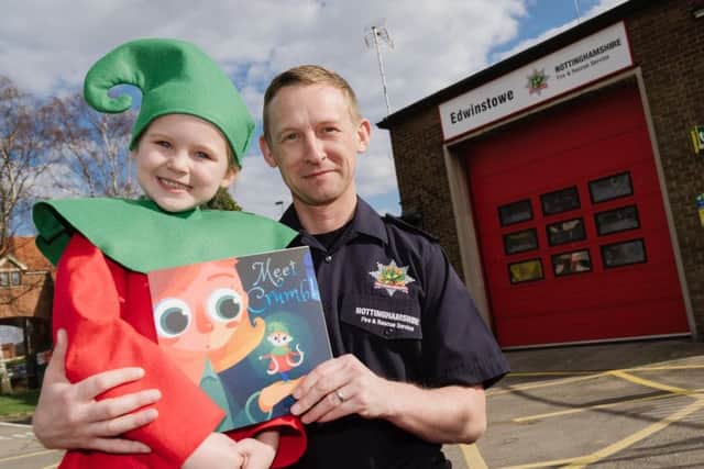 Jamie Croshaw with his book and one of its stars, his own seven-year-old daughter Darcey, at Edwinstowe Fire Station, where he works. (PHOTO BY:  Alex Skennerton, of Nottinghamshire Fire and Rescue Service)