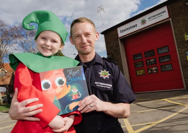 Jamie Croshaw with his book and one of its stars, his own seven-year-old daughter Darcey, at Edwinstowe Fire Station, where he works. (PHOTO BY:  Alex Skennerton, of Nottinghamshire Fire and Rescue Service)