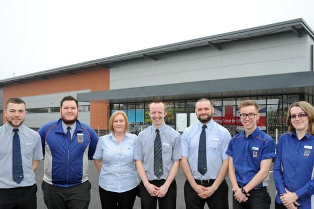 Store manager, Matt Hallam, centre, lines up with some of the staff ready to great customers to the new Aldi off Southwell Road West.