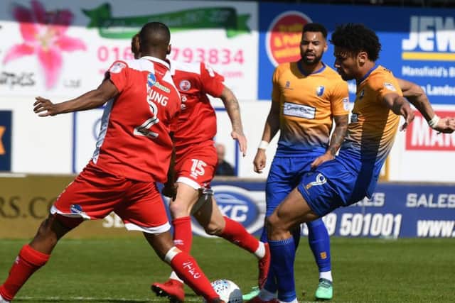 Lee Angol shoots against Crawley.