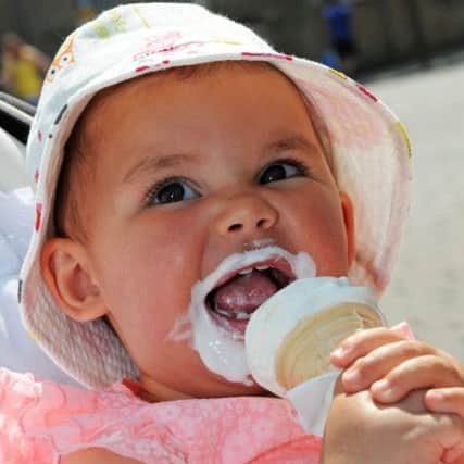 Seventeen month old Ava Candlin from Mansfield, cools off with an ice cream in Mansfield Market .