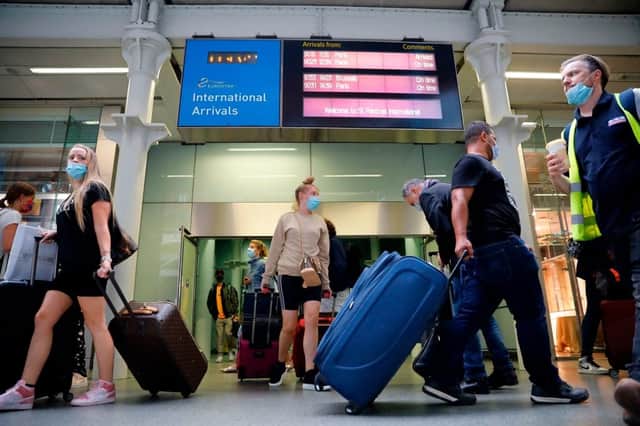 Passengers wearing facemasks as a precaution against the spread of the novel coronavirus walk through arrivals (Getty Images)